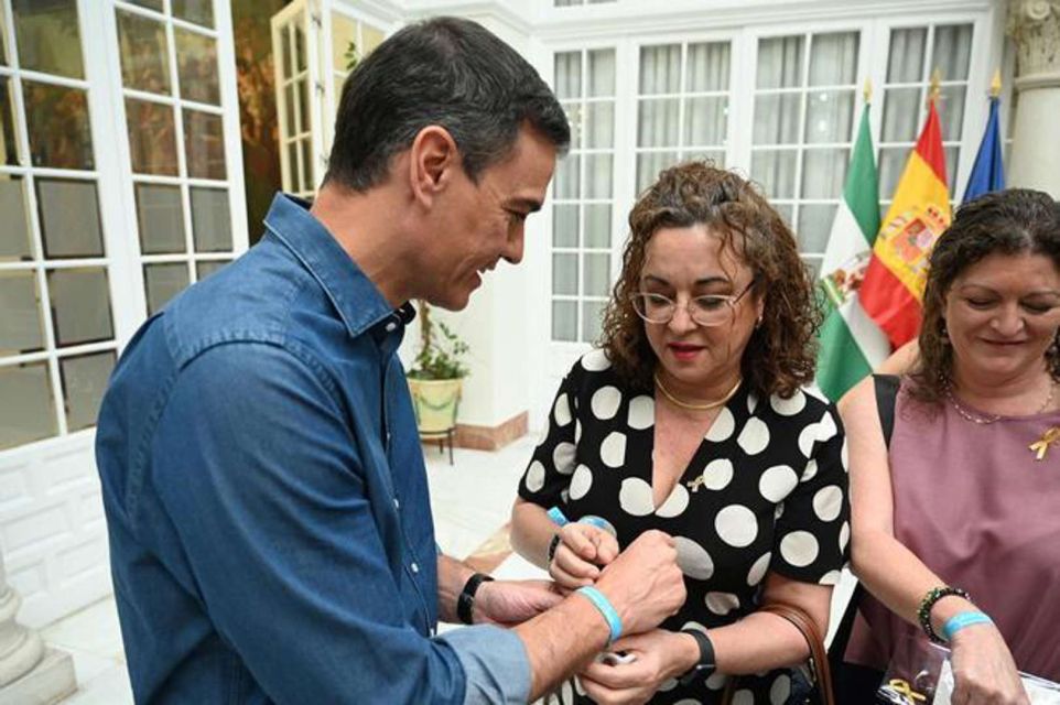 La gerente Pilar Flores dándole una pulsera de la Federación a Pedro Sánchez.